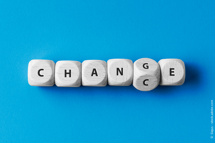 Sechs weiße Würfel liegen auf blauem Untergrund. Sie zeigen keine Augen, sondern Buchstaben, die die Worte Change und Chance bil
