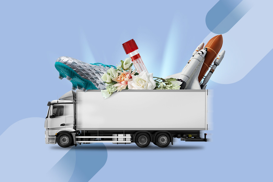Ein LKW, aus dem ein überdimensionaler Fußballschuh, eine Mini-Rakete, ein Laborglas und ein Brautstrauß herausragt